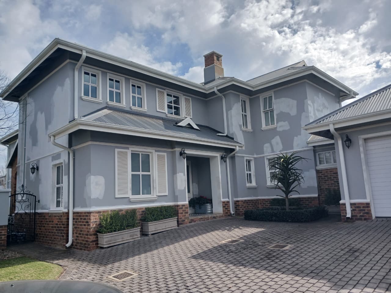 Contractor painting double story house facade